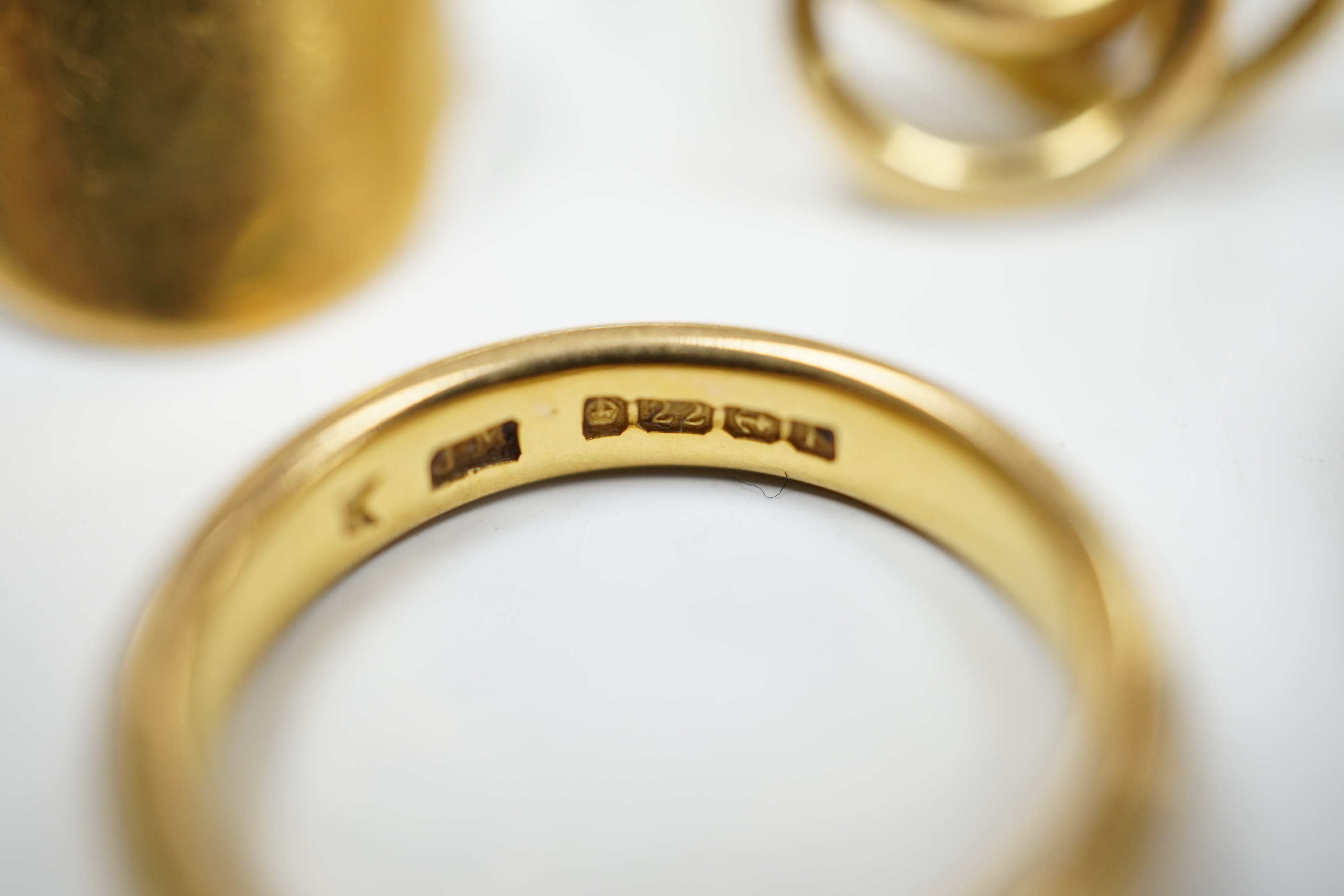 A 1930's 22ct gold wedding band, 5.9 grams, a 9ct gold wedding band, 5.1 grams and two other yellow metal rings, 10.1 grams.